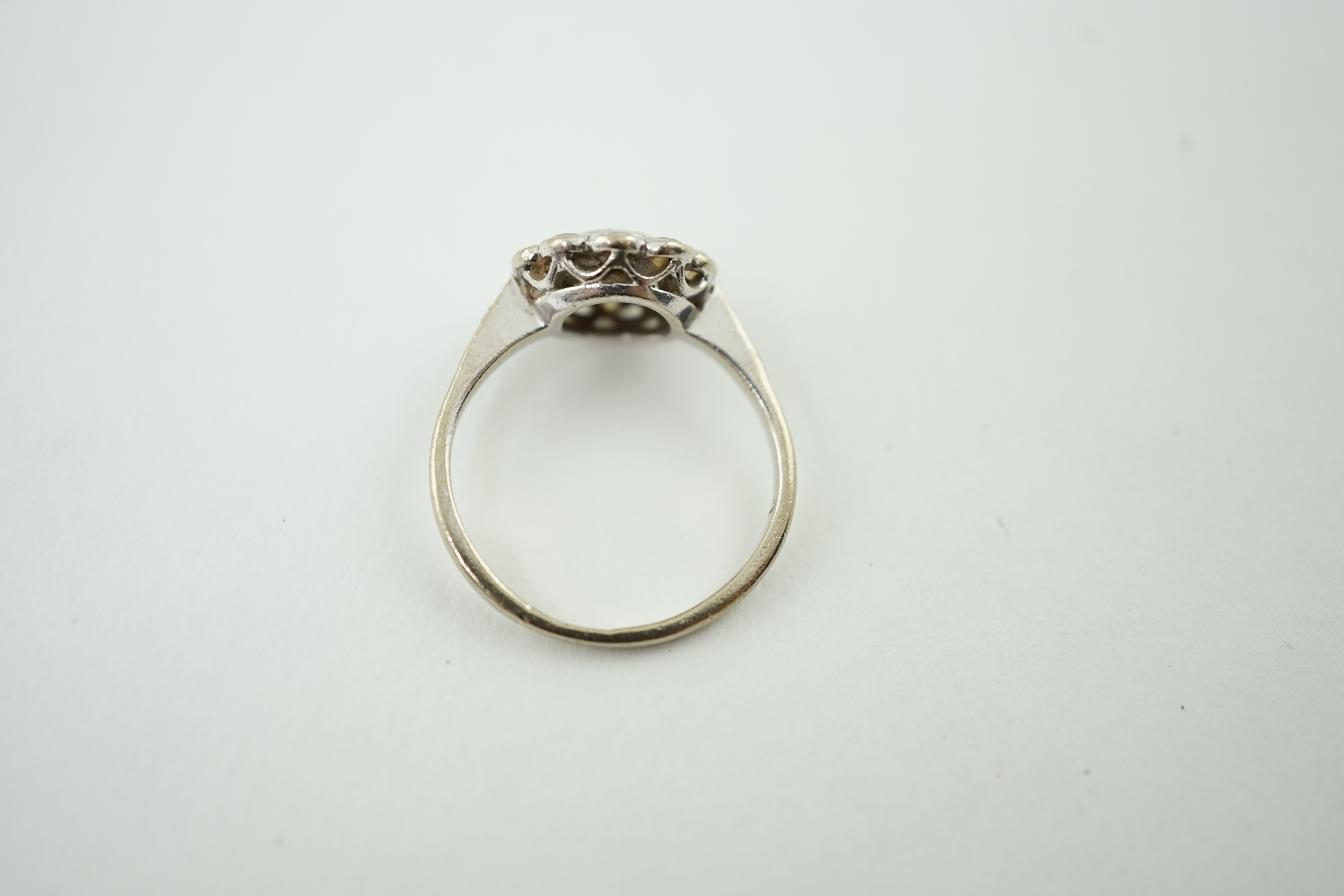 A mid 20th century 18ct white gold and eleven stone diamond set flower head cluster ring